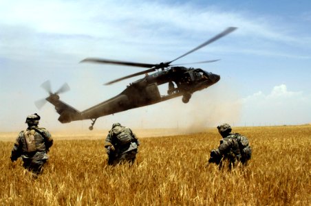 US Navy 060523-N-4614W-072 U.S. Army Spc. John Alden braces with his forward squad from Charlie Company, 1st Battalion, 327th Infantry Regiment, as a UH-60A Blackhawk arrives to extract them from a field outside Dugmat, Iraq