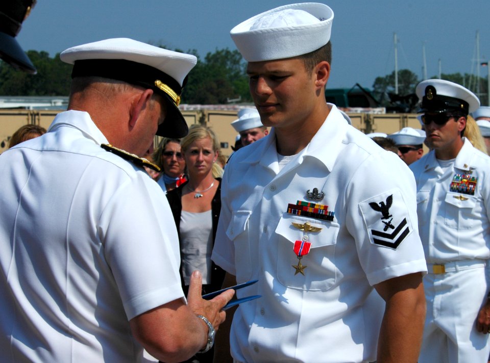 US Navy 060526-N-0635C-067 Rear Adm. Donald Bullard, commander, Navy Expeditionary Combat Command presents the Bronze Star with Combat Distinguishing Device to Gunner's Mate 2nd Class Bradley J. Sharp