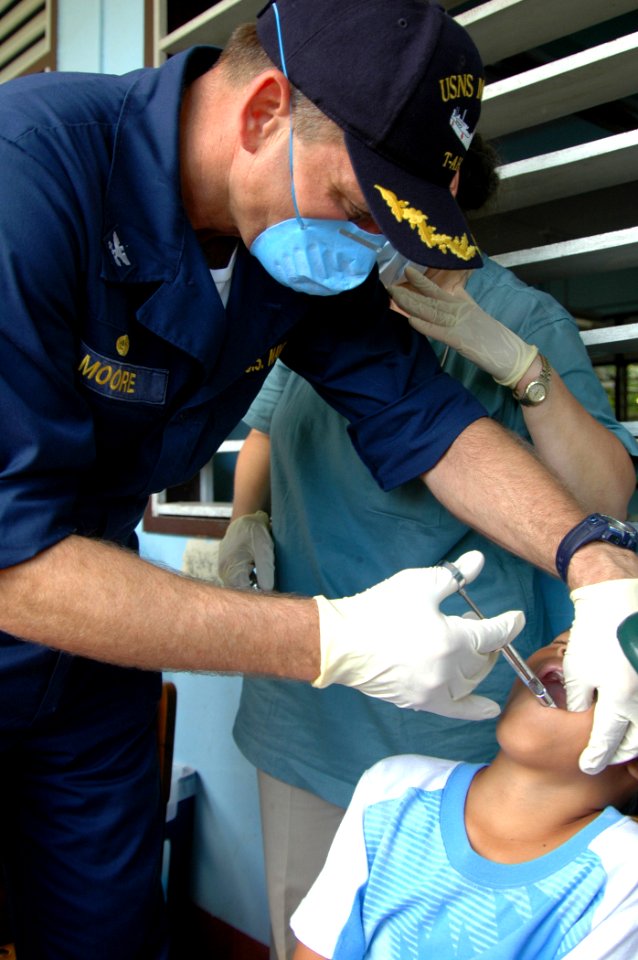 US Navy 060530-N-3532C-123 Navy Capt. Joseph Moore, commanding officer of the military treatment facility aboard U.S. Military Sealift Command (MSC) hospital ship, USNS Mercy (T-AH 19), injects anesthetic into a young child