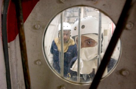 US Navy 060531-N-9851B-003 Damage control investigators, Republic of Singapore Navy (RSN) 2nd Sgt. Alvin Joseph Arozoo and Damage Controlman Fireman Alfonso Robeles approach a watertight door as they search for damage