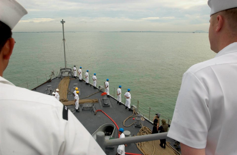 US Navy 060529-N-9851B-002 Sailors man the rails of amphibious dock landing ship USS Tortuga (LSD 46) as she pulls into Changi Naval Base, Singapore