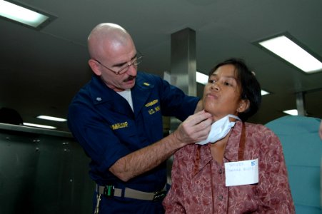 US Navy 060612-N-3532C-009 Navy Cmdr. Kurt Hummeldorf, a maxillofacial surgeon with the Medical Treatment Facility aboard the U.S. Military Sealift Command (MSC) Hospital Ship USNS Mercy (T-AH 19), examines a local resident