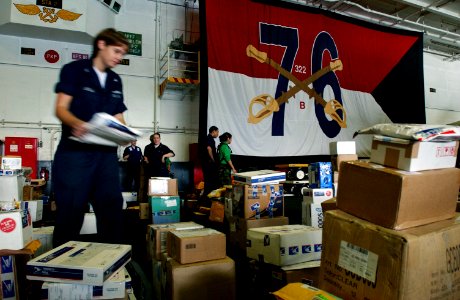 US Navy 060525-N-7526R-066 Postal Clerk 3rd Class Kayla Glasgow separates mail on the hangar bay floor after receiving it from the Military Sealift Command (MSC) Fast Combat Support ship USNS Rainier (T-AOE 7)