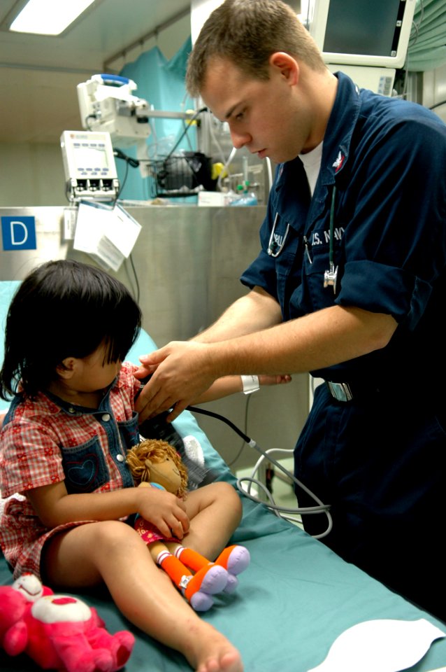 US Navy 060603-N-3714J-017 Navy Hospital Corpsman 3rd Class Marcus Ferrill, of Cameron, Calif., takes a child's blood pressure