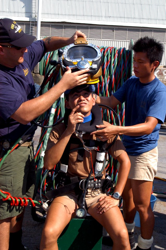 US Navy 060602-N-4205W-002 Chief Quartermaster Russell Ciardello and Republic of Singapore Navy (RSN) 1st Sgt. Adrian Tay assist RSN Maj. Yip Wai Choong as prepares to dive from the Safeguard-class Salvage ship USS Salvor (ARS