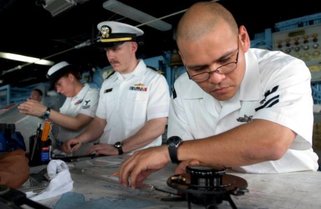 US Navy 060614-N-9851B-011 Quartermaster 2nd Class Christian Castillo tracks the course of amphibious dock landing ship USS Tortuga (LSD 46) from the ship's bridge