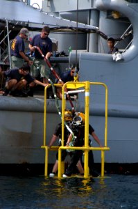 US Navy 060607-N-4205W-008 1st Sgt. Adrian Tay from the Republic of Singapore Navy (RSN) and Machinist's Mate 3rd Class Scott Gee are raised from the water with a stage from the side of rescue and salvage ship USS Salvor (ARS 5