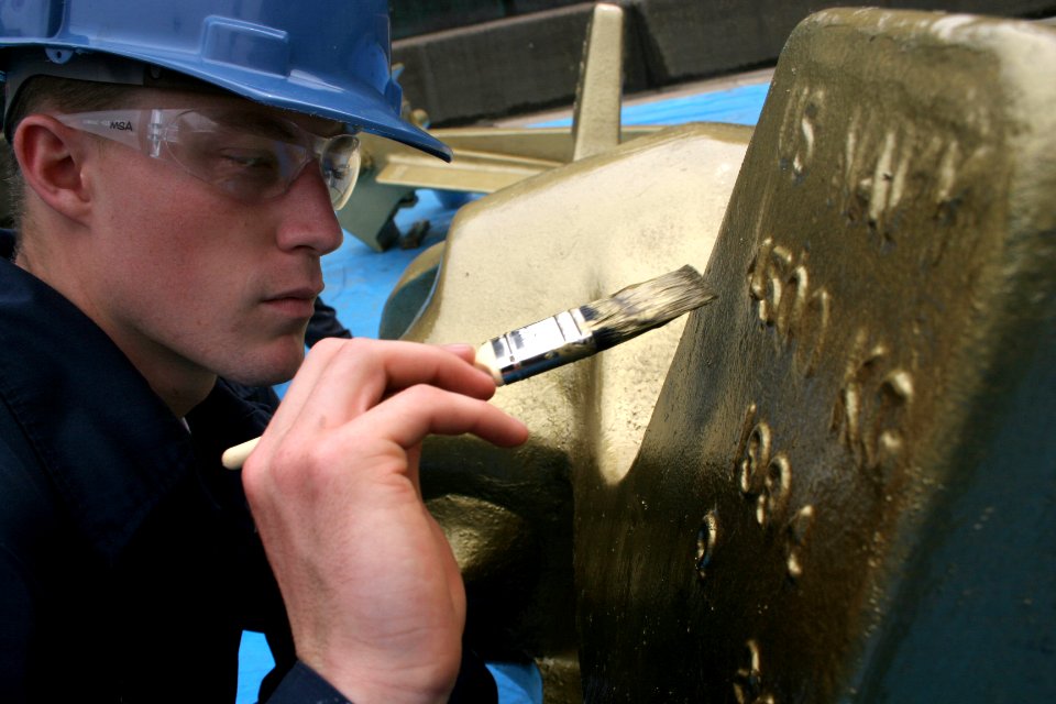 US Navy 060616-N-4953E-007 Boatswain's Mate 3rd Class Tyler Neve paints one of the 9000 lb Navy Standard Stockless Anchors gold after the guided-missile destroyer USS Stethem (DDG 63) was awarded the Gold Anchor for retention