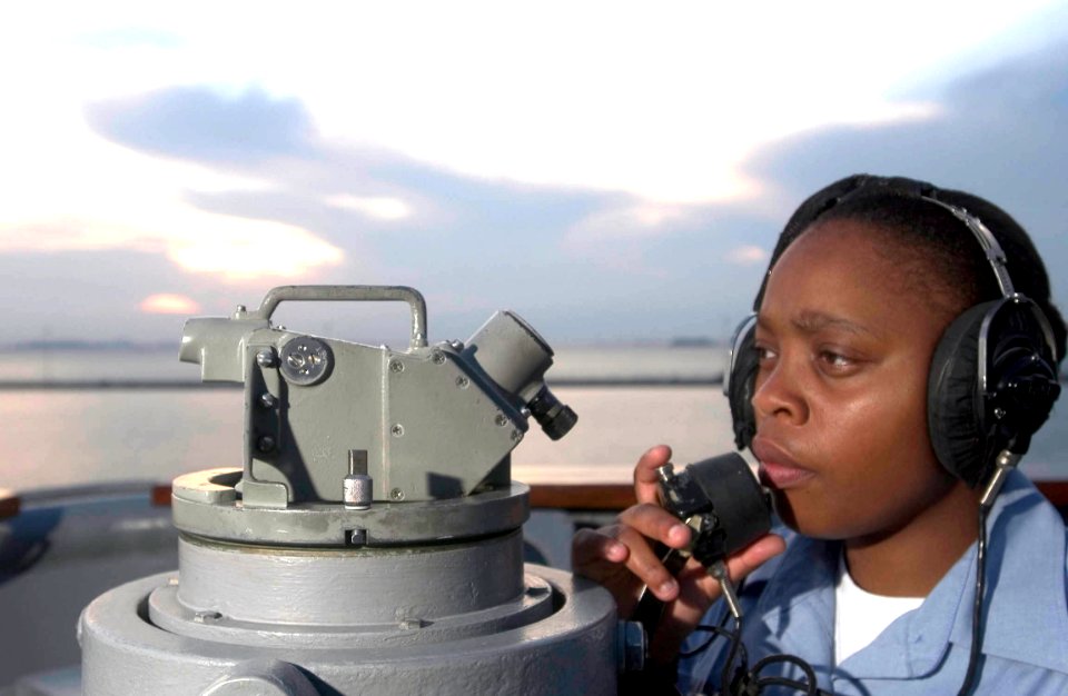 US Navy 060605-N-9851B-001 Quartermaster 3rd Class Jessica Mason takes bearings from the portside bridge wing of the amphibious dock landing ship USS Tortuga (LSD 46)