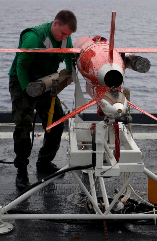 US Navy 060608-N-9851B-007 Machinery Repairman 2nd Class Donald Usher assigned to Commander Fleet Activities Okinawa Drone Detachment, removes a jet assisted take off (JATO) from a BQM-74E aerial target on the flight deck of am