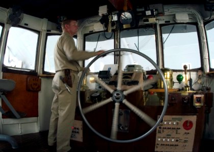 US Navy 060525-N-2385R-003 Chief Boatswain's Mate Richard Copeland assigned to Port Operations, maneuvers the Natick-class large harbor tug USS Manistee (YTB 782) at the bow of the conventional aircraft carrier USS Kitty