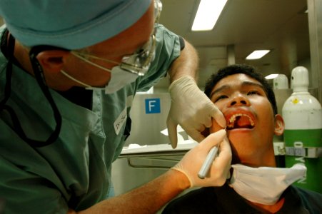US Navy 060607-N-2832L-053 Air Force Col. Jeffrey Swartz, a dentist, pulls teeth from patients aboard the U.S. Military Sealift Command (MSC) hospital ship USNS Mercy (T-AH 19)