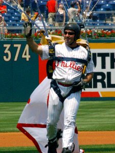 US Navy 060618-N-4729H-077 Leapfrogs, Navy Parachute Team member, Navy SEAL (Sea, Air and Land) Nix White, sports a Philadelphia Phillies' home uniform, as he lands on the baseball field during the pre-game show