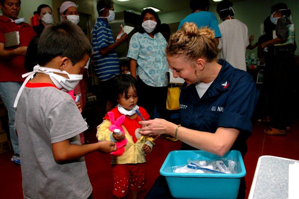 US Navy 060608-N-3714J-033 Navy Hospital Corpsman 2nd Class Tracy Scott, of Largo, Fla., distributes toothbrushes to children during a Medical and Dental Civil Action Project held aboard the U.S. Military Sealift Command (MSC)