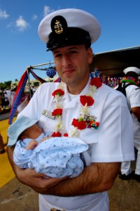 US Navy 060525-N-9643K-008 Senior Chief Woodrow Purkey meets his 7-day-old son for the first time, following the return of the guided-missile destroyer USS Chung-Hoon (DDG 93) to Pearl Harbor after a four-month maiden deploymen