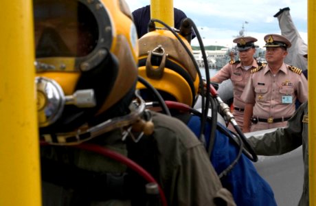 US Navy 060621-N-9851B-007 Deputy Commander of Frigate Squadron Two, Royal Thai Navy Capt. Wirat Somjit, observes as a U.S. Navy diver and a Royal Thai Navy diver are lowered into the water on a diving stage from rescue and sal