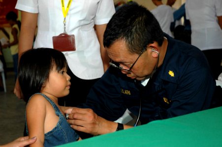 US Navy 060611-N-1577S-112 Navy Cmdr. Jesus Mallari assigned to the U.S. Military Sealift Command (MSC) Hospital Ship USNS Mercy (T-AH 19), examines a patient photo