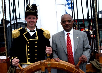 US Navy 060623-N-5367L-002 Commanding Officer, Cmdr. Thomas C. Graves, and Assistant Secretary of the Navy for Installations and Environment, the Honorable B.J. Penn, man the helm aboard USS Constitution