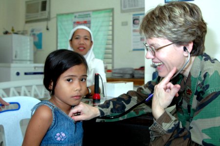 US Navy 060613-N-3532C-034 Air Force Maj. Valerie Clegg, a pediatrician with the Medical Treatment Facility aboard the U.S. Military Sealift Command (MSC) Hospital Ship USNS Mercy (T-AH 19), examines a young girl