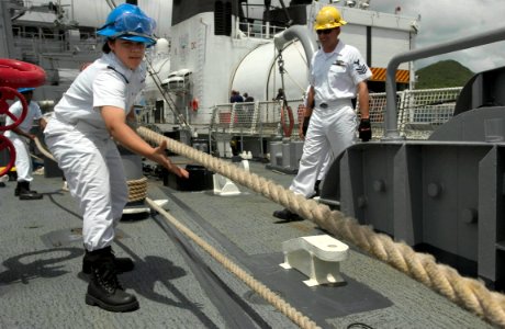 US Navy 060627-N-9851B-001 Seaman Carmin Killingbeck heaves in a mooring line as rescue and salvage ship USS Salvor (ARS 52) departs Thailand