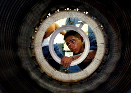 US Navy 060607-N-6524M-002 Aviation Machinist's Mate Airman Hillario Arreola inspects an F-A-18C jet engine in the Jet shop aboard the nuclear-powered aircraft carrier USS Enterprise (CVN 65)