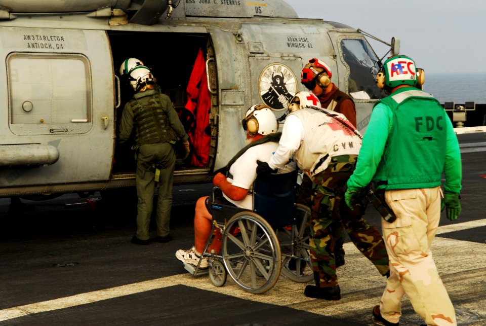 US Navy 060703-N-3729H-050 A civilian sports fisherman is wheeled to an SH-60F Seahawk assigned to the Eightballers of Helicopter Anti-Submarine Squadron Eight (HS-8) after being treated for head injuries