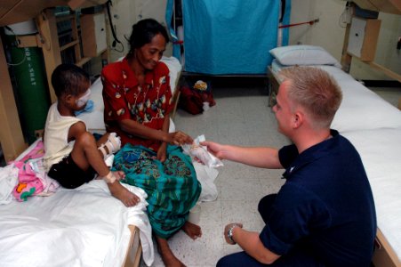 US Navy 060614-N-1577S-003 Navy Aviation Electronics Technician 3rd Class Eric Bloom of Minneapolis, offers cookies to a patient's mother