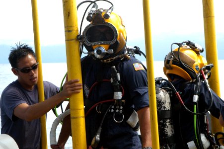 US Navy 060606-N-4205W-009 Master Sgt. David Ling from the Republic of Singapore Navy (RSN) stage handles Gunner's Mate 2nd Class Brian Zenoni and Lt. Chan Tse Chi Grace, RSN, after they conducted a dive