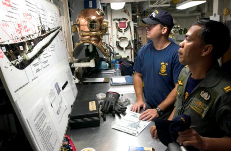 US Navy 060621-N-9851B-001 U.S. Navy diver Hospital Corpsman 2nd Class Brad O'Keefe shows Royal Lt.j.g. Mongkol Podang a drawing of USS Lagarto (SS 371) during a visit to rescue and salvage ship USS Salvor (ARS 52)