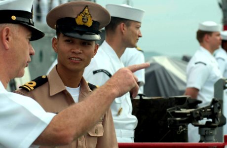 US Navy 060618-N-9851B-002 Command Master Chief Joseph Diaz talks with Royal Thai Navy liaison officer Lt.j.g. Sunate Kumwing Sa on the deck of amphibious dock landing ship USS Tortuga (LSD 46) as the ship enters port