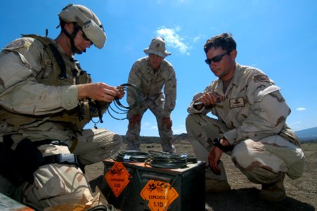 US Navy 060810-N-0411D-019 U.S. Marine Cpl. Justin Lefan, center, watches U.S. Navy Explosives Ordnance Disposal Specialist 2nd Class Corey Baughmann, left, as he measures off fifteen feet of time fuse