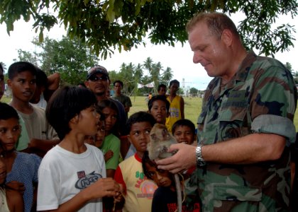 US Navy 060616-N-8391L-116 U.S. Navy Chief Michael Gallagher spends time with the domestic monkey of a small child during a medical assistance mission deployed from the U.S. Military Sealift Command (MSC) Hospital Ship USNS Mer