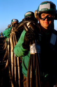 US Navy 060613-N-9723W-054 Airman Jerod Dickson and other Sailors prepare to stow the aircraft baracade on the flight deck aboard the Nimitz-class aircraft carrier USS John C. Stennis (CVN 74)