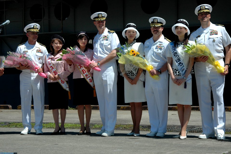 US Navy 060701-N-1332Y-094 Rear Adm. Doug McClain, USS Kitty Hawk (CV 63) Commanding Officer, Capt. Ed McNamee, Capt. Michael McNellis and Commander, Destroyer Squadron One Five, Capt. Robert Girrier, receive flowers as they ar