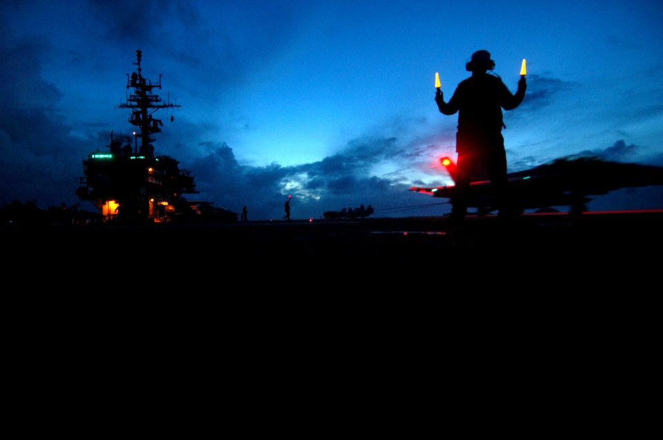 US Navy 060622-N-9389D-096 An Air Department Sailor directs an F-A-18C Hornet after a successful landing on the flight deck aboard the conventionally-powered aircraft carrier USS Kitty Hawk (CV 63)