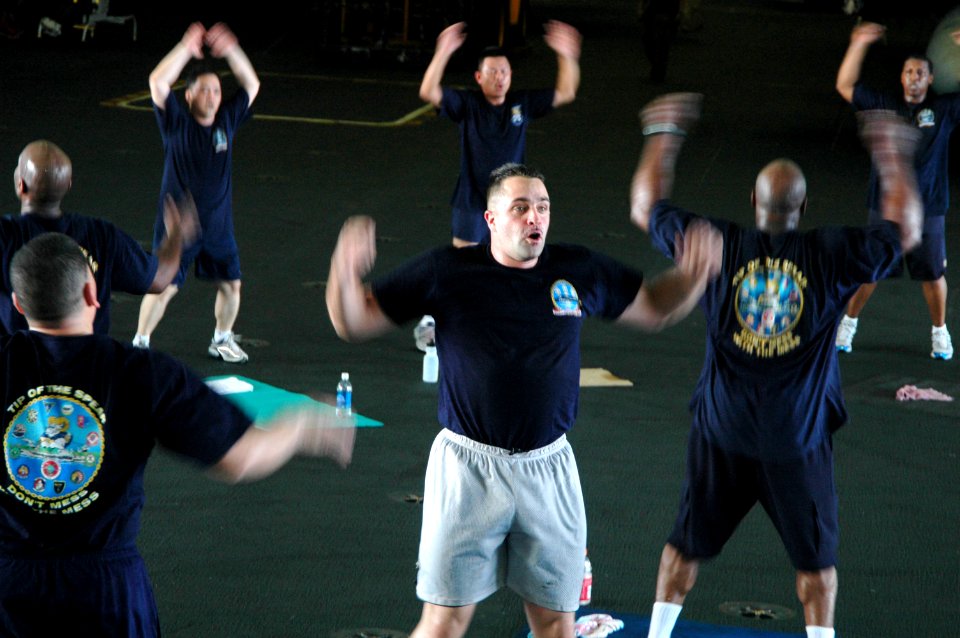 US Navy 060623-N-9389D-184 Conventionally-powered aircraft carrier USS Kitty Hawk (CV 63) Chiefs' Mess Sailors exercise during a physical training (PT) session in the hangar bay during Exercise Valiant Shield 2006