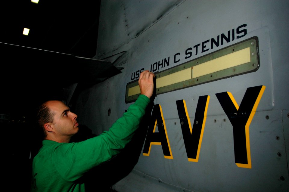 US Navy 060701-N-2659P-066 Aviation Electrician's Mate 1st Class Hector Viramontes checks the waterproofing on a fuselage light of an F-A-18C Hornet