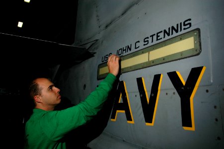 US Navy 060701-N-2659P-066 Aviation Electrician's Mate 1st Class Hector Viramontes checks the waterproofing on a fuselage light of an F-A-18C Hornet