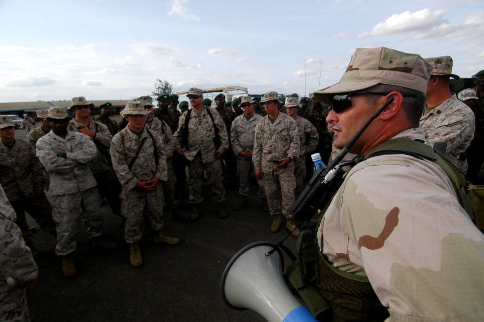 US Navy 060802-N-0411D-004 U.S. Navy Lt. j.g. Robert Mock of Mobile, Ala. gives U.S. Marines and Kenyan Army Soldiers a wrap up of the day's events aU.S. Navy Lt. j.g. Robert Mock of Mobile, Ala. gives U.S. Marines and Kenyan A