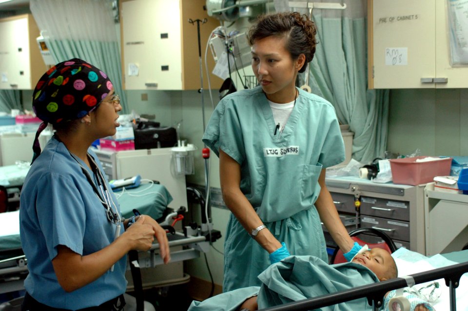 US Navy 060702-N-9076B-078 U.S. Navy Lt.j.g. Cathrine Soteras of Long Beach, Calif., discuses a patients condition with Operation Smile nurse Simran Singh of Canada, in a recovery room aboard U.S. Naval hospital ship USNS Mercy