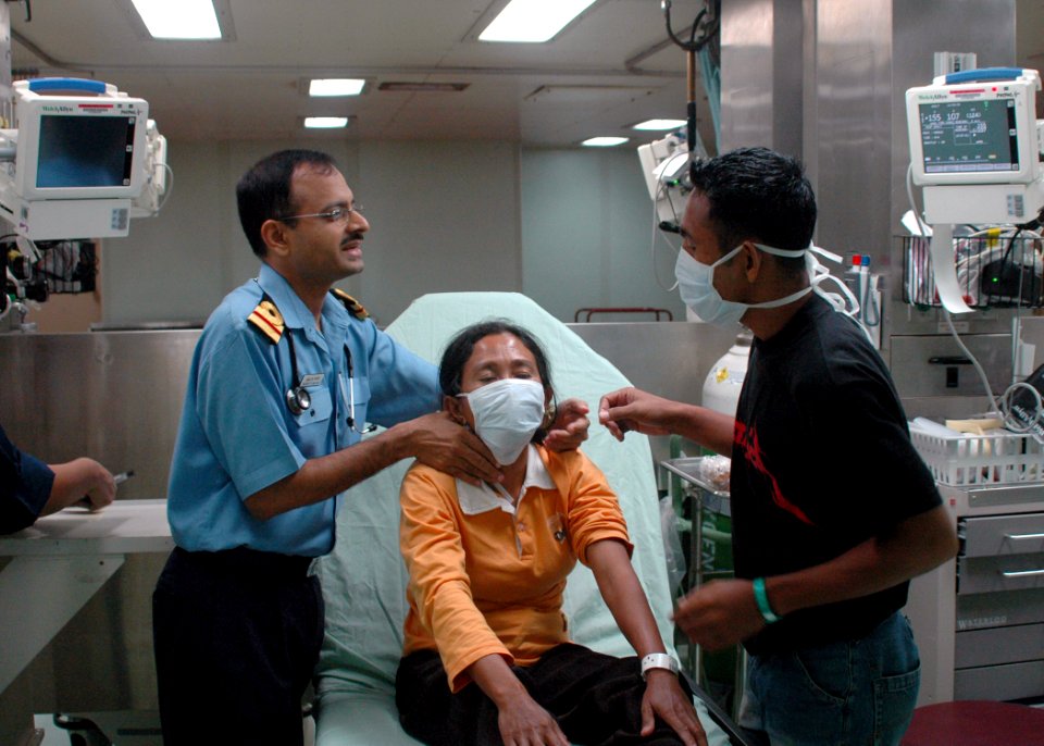 US Navy 060614-N-9076B-190 Indian Navy Lt. Akshay Nayak, attached to the Medical Treatment Facility aboard the U.S. Military Sealift Command (MSC) Hospital Ship USNS Mercy (T-AH 19), talks with a patient
