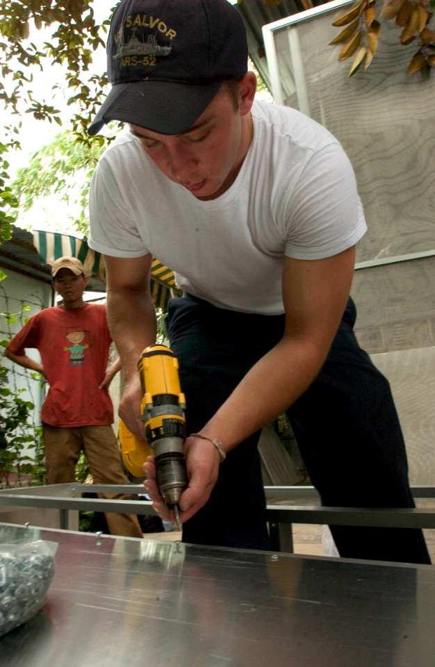 US Navy 060703-N-9851B-007 Information Systems Technician 3rd Class Kyle Porter, assigned to the rescue and salvage ship USS Salvor (ARS 52), assembles metal shelving to be used in Thien Binh Orphanage