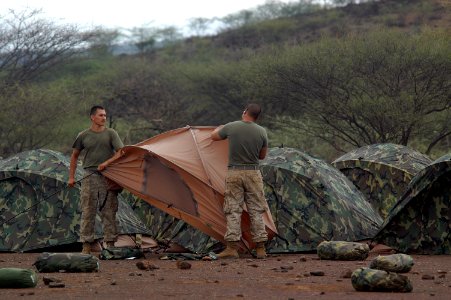 US Navy 060805-N-0411D-018 Lance Cpl. Adam Orozco, left, and Lance Cpl. Simon Lin assemble a series of two-man tents at Camp Lonestar
