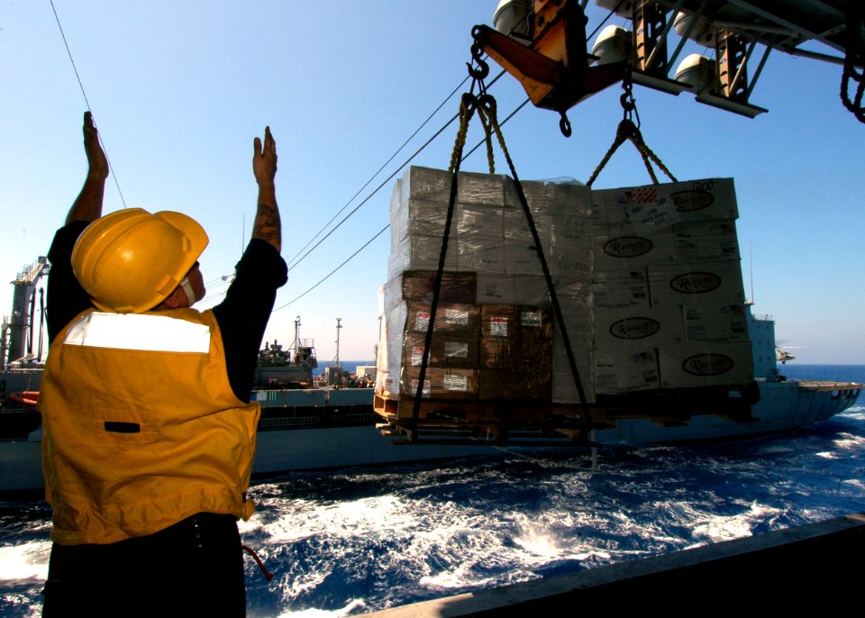 US Navy 060812-N-6403R-003 Boatswain's Mate 2nd Class Kevin Teruya provides a visual reference to the deck hands aboard the Military Sealift Command (MSC) underway replenishment oiler USNS Kanawha