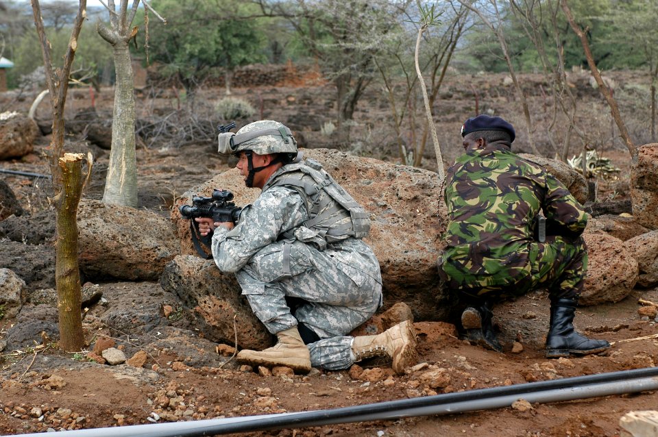 US Navy 060806-N-0411D-013 Guam Army National Guard Staff Sgt. Jay Antenocruz takes up a firing position with a Kenyan Army soldier at the perimeter of Natural Fire Headquarters as part of a mock attack drill