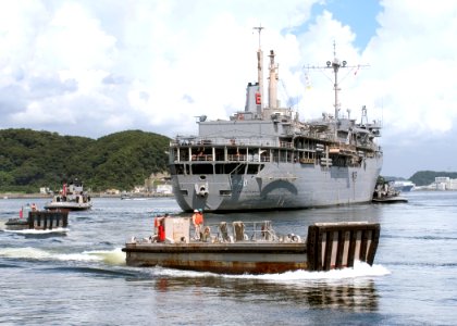 US Navy 060814-N-2716P-065 Pusher boats pull back into port as tugboats escort the submarine tender USS Frank Cable (AS 40) as it departs Commander Fleet Activities Yokosuka, Japan after a routine port visit
