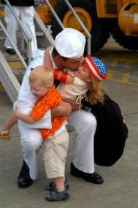 US Navy 060703-N-6247M-005 Interior Communications Electrician 2nd Class Fletcher Hendrickson hugs his children during a homecoming celebration for the guided-missile frigate USS Ford (FFG 54)