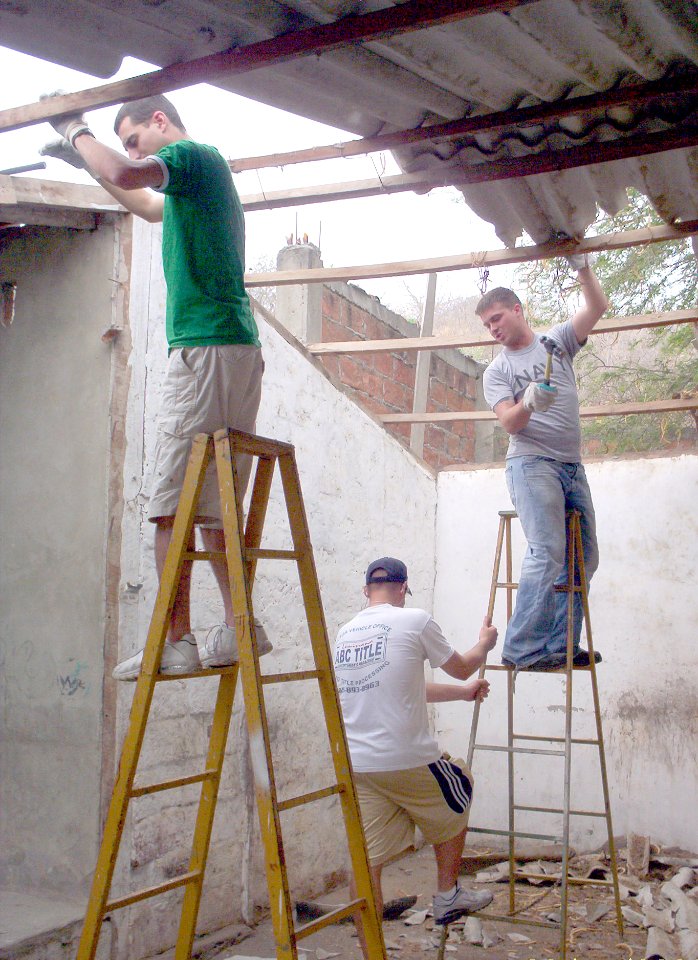 US Navy 060814-N-4040H-002 Boatswain Mate 2nd Class Randall McNeil, left and Hull Technician Fireman Alex Anderson, right, balance on ladders as they begin the demolition of the old roof over the kitchen for the Jorge Washingt