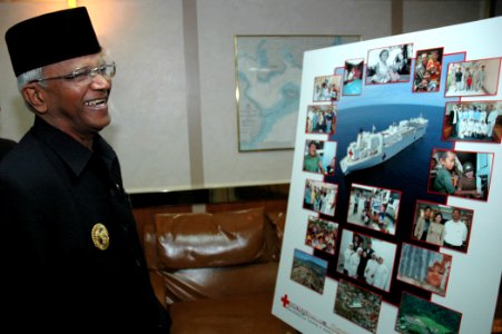US Navy 060816-N-1577S-005 Mayor of Tarakan, H. Jusuf SK views a poster of various photos showing humanitarian and civic assistance being conducted in Tarakan by personnel photo