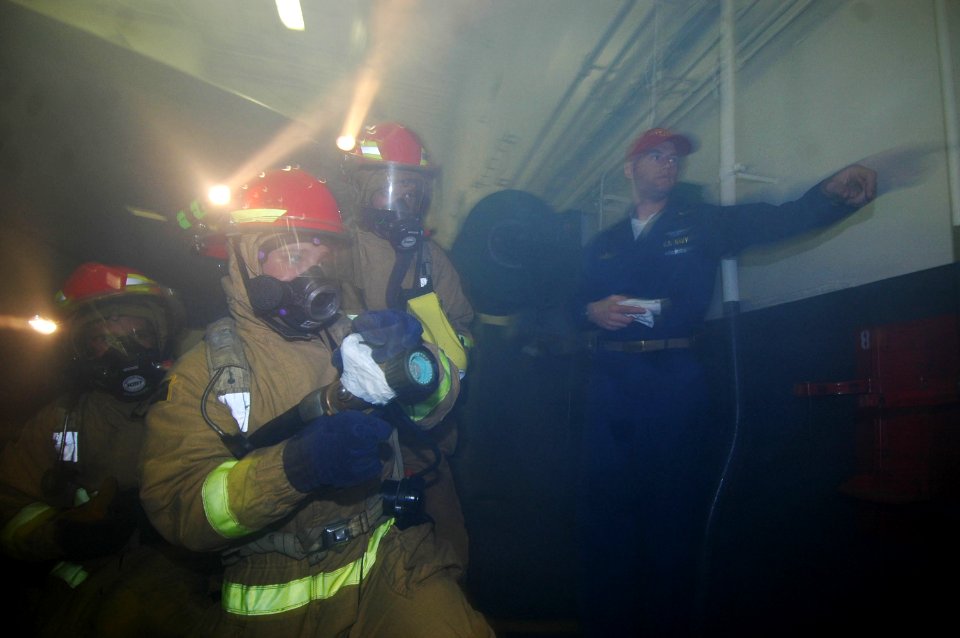 US Navy 060815-N-8604L-047 The Repair Locker 1B Hose Team battles a simulated hangar bay fire during a General Quarters (GQ) drill